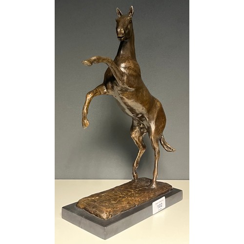 102 - Bronze sculpture of a horse rearing. Fitted upon a black slate base. [37cm high]