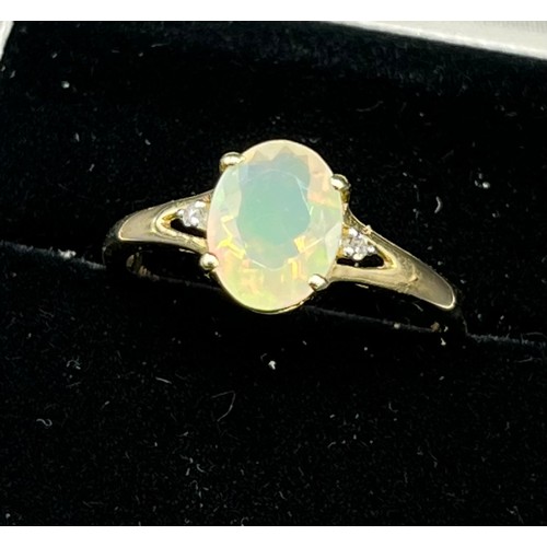 203 - 10ct yellow gold ladies ring set with a single opalescent style stone off set by diamond shoulders [... 