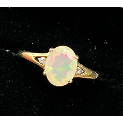 203 - 10ct yellow gold ladies ring set with a single opalescent style stone off set by diamond shoulders [... 