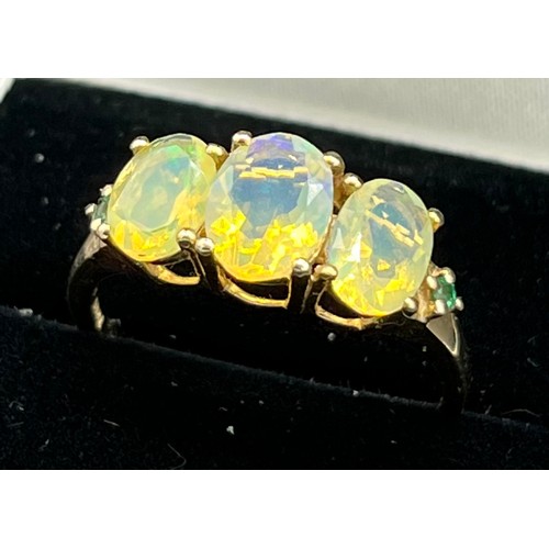 201 - 9ct yellow gold ladies ring set with three large opalescent style stones off set by emerald shoulder... 