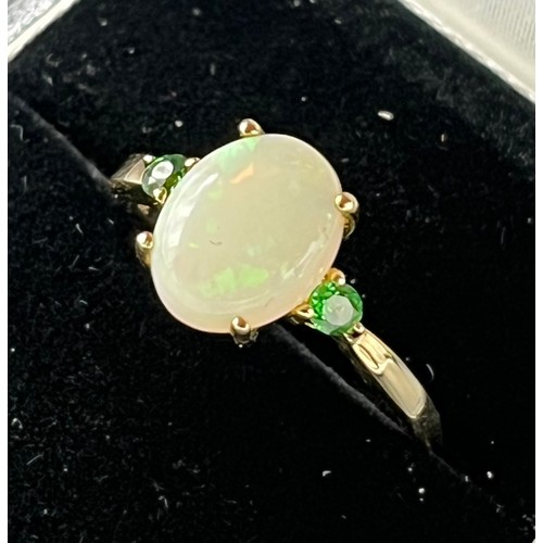 59 - 10ct yellow gold ladies ring set with an oval cut opal centre stone off set by green Tourmaline ston... 