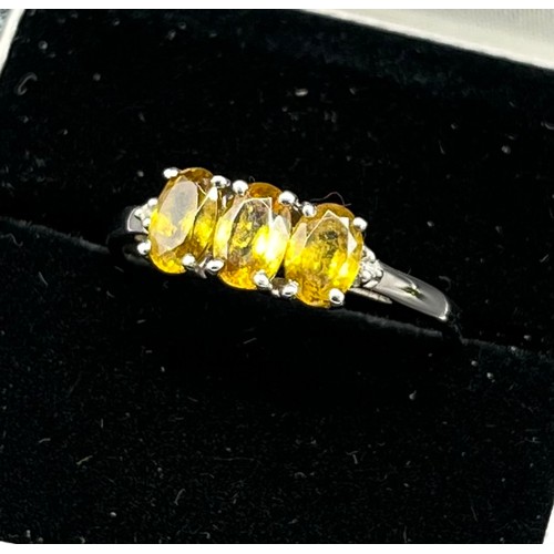 65 - 10ct white gold ladies ring set with three yellow tourmaline stones off set by a diamond to each sho... 