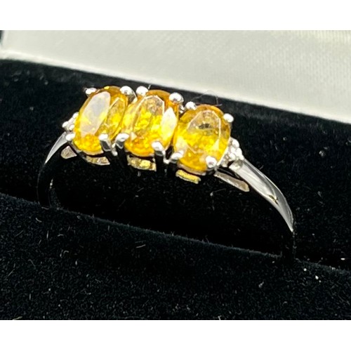 65 - 10ct white gold ladies ring set with three yellow tourmaline stones off set by a diamond to each sho... 