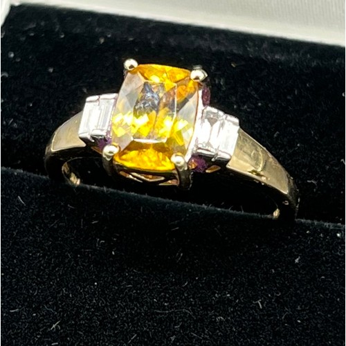 69 - 14ct yellow gold ladies ring set with a large yellow tourmaline stone off set by emerald cut diamond... 