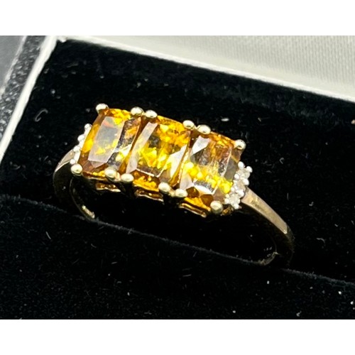 81 - 10ct yellow gold ladies ring set with three emerald cut yellow tourmaline stones off set by diamond ... 