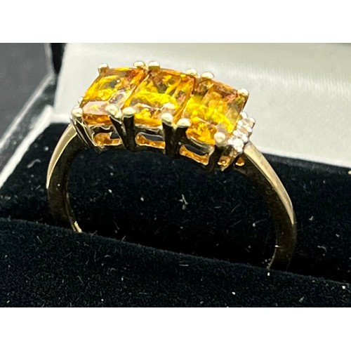 81 - 10ct yellow gold ladies ring set with three emerald cut yellow tourmaline stones off set by diamond ... 