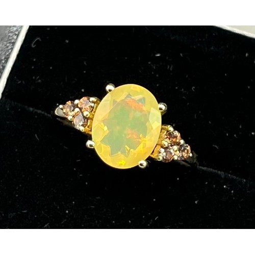 87 - 10ct yellow gold ladies ring set with a large opalescent style stone off set by smokey quartz should... 