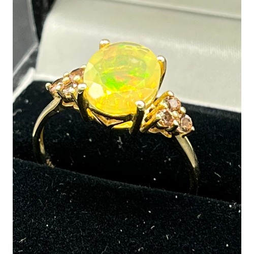 87 - 10ct yellow gold ladies ring set with a large opalescent style stone off set by smokey quartz should... 