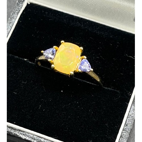 96 - 10ct yellow gold ladies ring set with an opalescent style stone off set by purple tourmaline stone s... 