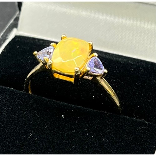 96 - 10ct yellow gold ladies ring set with an opalescent style stone off set by purple tourmaline stone s... 