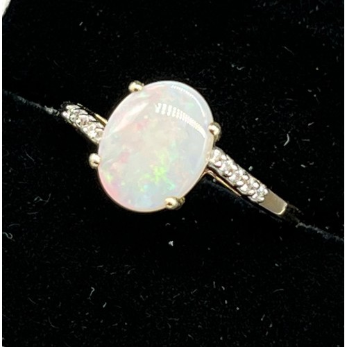 99 - 10ct yellow gold ladies ring set with an opal stone off set by white topaz shoulders. [Ring size P] ... 