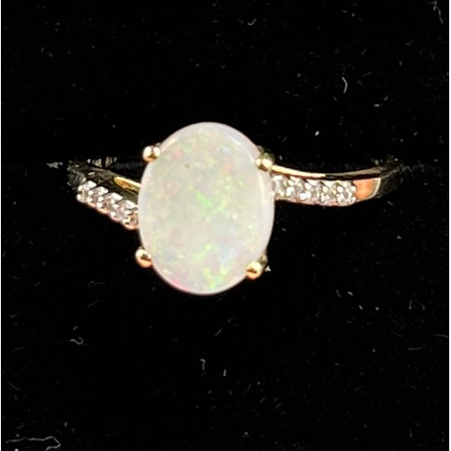 99 - 10ct yellow gold ladies ring set with an opal stone off set by white topaz shoulders. [Ring size P] ... 