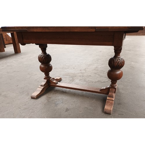 352 - Antique oak extending dining table, the rectangular surface raised by carved acorn design columns en... 