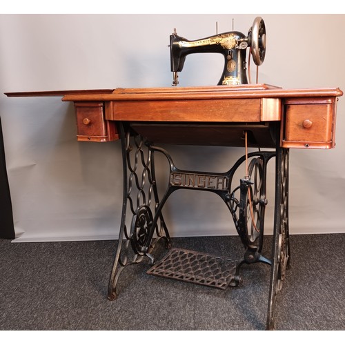 353 - Antique pedal singer sewing machine, raised and supported on a cast iron base. [78x90x44cm]