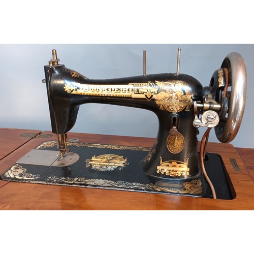 353 - Antique pedal singer sewing machine, raised and supported on a cast iron base. [78x90x44cm]