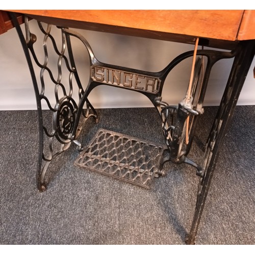 353 - Antique pedal singer sewing machine, raised and supported on a cast iron base. [78x90x44cm]