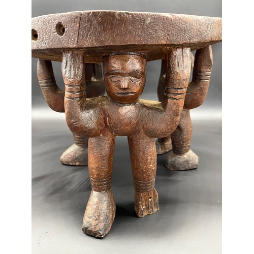 134 - Hand carved African tribal stool, supports are made up of three carved figures. [33x40cm]