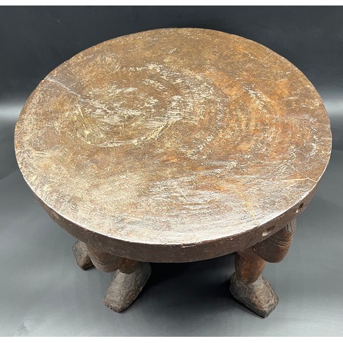 134 - Hand carved African tribal stool, supports are made up of three carved figures. [33x40cm]