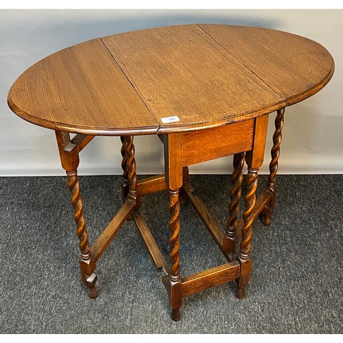 306 - Antique oak table, the oval surface with drop ends, raised on barley twist legs [74x90x60cm]