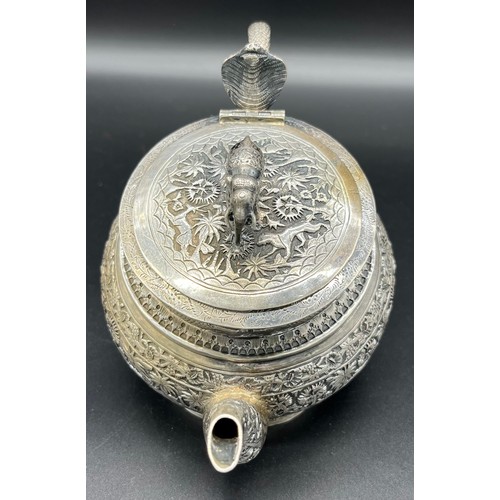 79 - A Colonial Indian Silver tea pot, rested at an angle, highly decorative body, lid detailed with an e... 