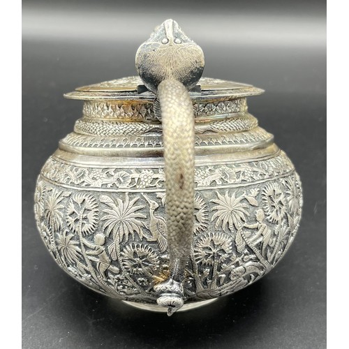 79 - A Colonial Indian Silver tea pot, rested at an angle, highly decorative body, lid detailed with an e... 