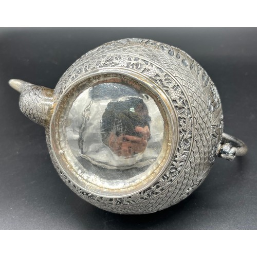 79 - A Colonial Indian Silver tea pot, rested at an angle, highly decorative body, lid detailed with an e... 