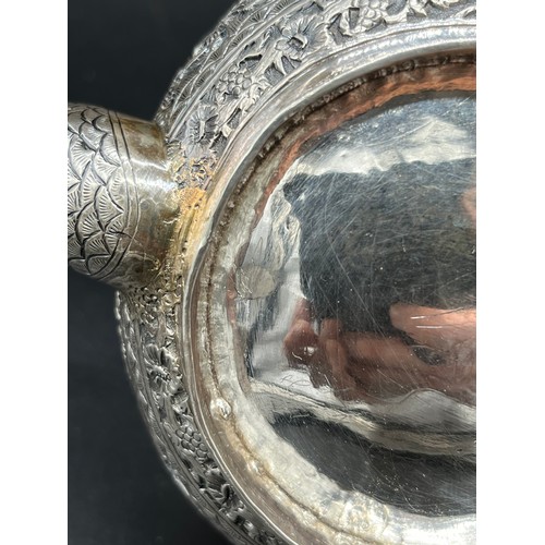 79 - A Colonial Indian Silver tea pot, rested at an angle, highly decorative body, lid detailed with an e... 