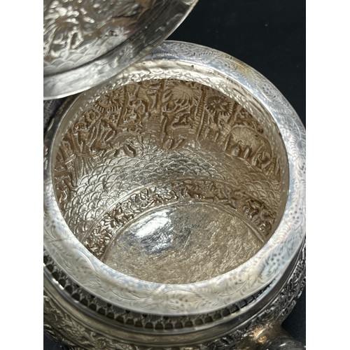 79 - A Colonial Indian Silver tea pot, rested at an angle, highly decorative body, lid detailed with an e... 