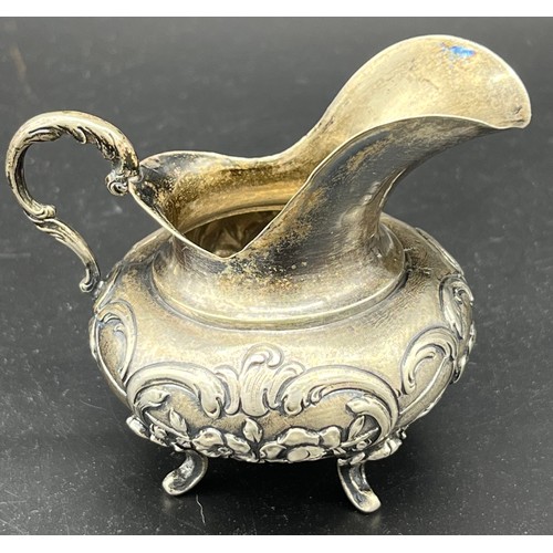 83 - German 800 Grade silver, small cream jug, highly decorated and supported on four out swept feet [7cm... 