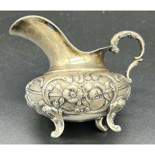 83 - German 800 Grade silver, small cream jug, highly decorated and supported on four out swept feet [7cm... 