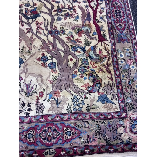 402 - A Quality Asian Wool Rug depicting a wood scene with exotic birds and animals. L 230 X w 138