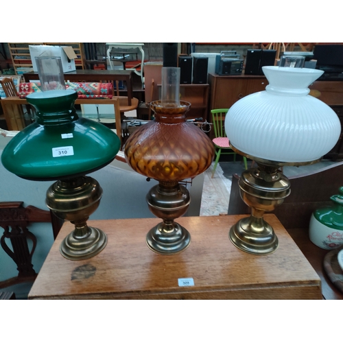 310 - 3 Vintage brass paraffin lamps with glass funnels and cover shades