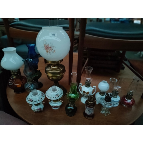 345 - Collection of various oil lamps includes brass oil lamp with globe cover