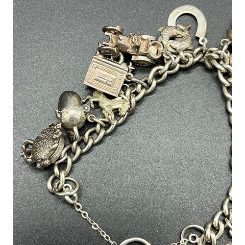 12 - Silver charm bracelet and charms. 14 charms present.