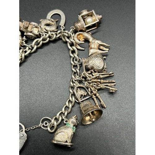 12 - Silver charm bracelet and charms. 14 charms present.