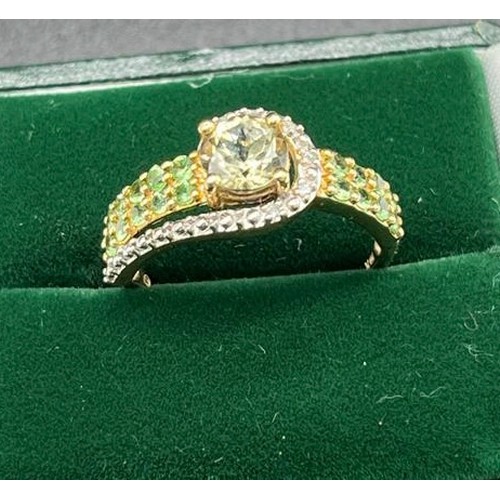 18 - Ladies 10ct yellow gold ring set with a large round cut pale green topaz off set by green tourmaline... 