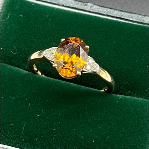 506 - 10ct yellow gold ladies ring set with an orange tourmaline stone off set by diamond shoulders. [2.05... 