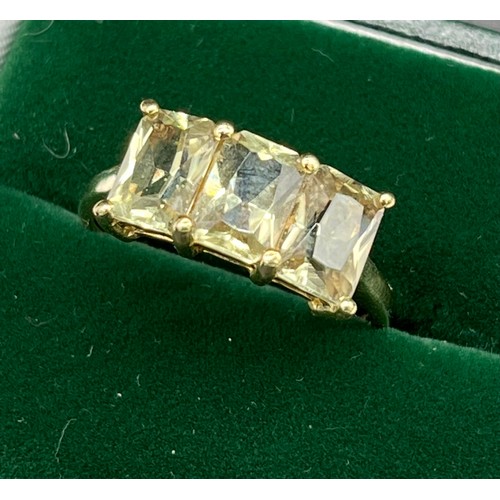 515 - 10ct yellow gold ladies ring set with three emerald cut pale green topaz stones. [Ring size P] [2.81... 