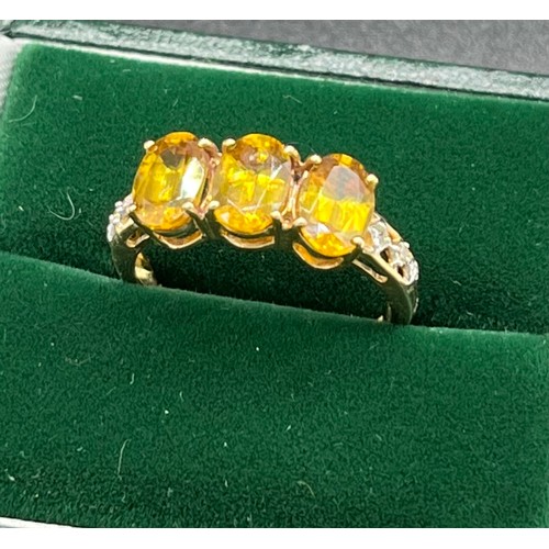 518 - 10ct yellow gold ladies ring set with three oval cut yellow/ orange tourmaline stones off set by dia... 