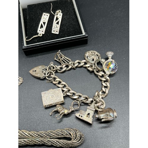 24A - A Selection of silver jewellery to include Gate bracelet with various charms.