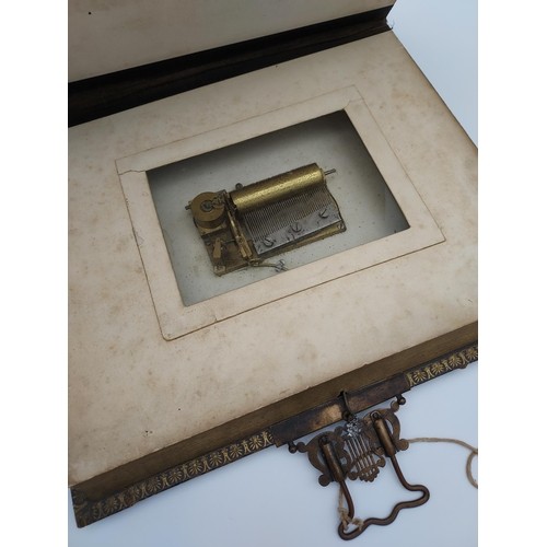 725 - A Victorian photograph album with an in-built musical mechanism [comes with wind up key] finished wi... 