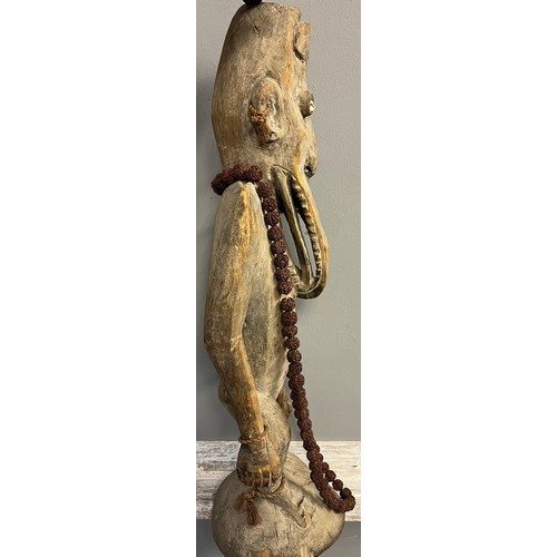 550 - Antique hand carved African Tribal Figure, Elongated face, comes with nut necklace. [72cm high]