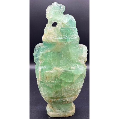 606 - A Chinese carved rock crystal lidded urn, carved in archaic style with scrolling foliage amongst lio... 