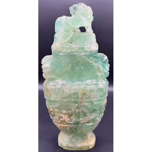 606 - A Chinese carved rock crystal lidded urn, carved in archaic style with scrolling foliage amongst lio... 