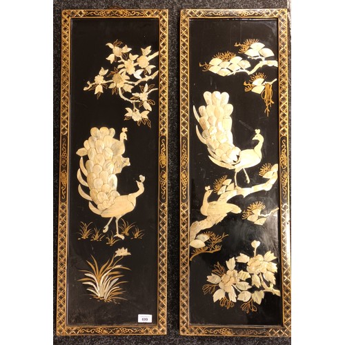 699 - A pair of Chinese lacquered panels depicting peacocks made from mother of pearl. [93x41cm]