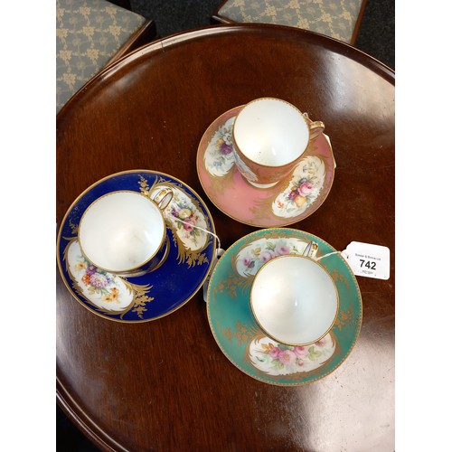 742 - A lot of three Antique hand painted cups and saucers. Detailed with gilt trims and bouquets of hand ... 