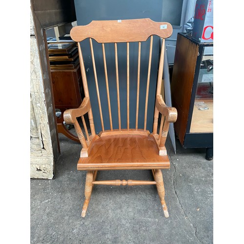 68 - Light wood rocking chair with arm rests.