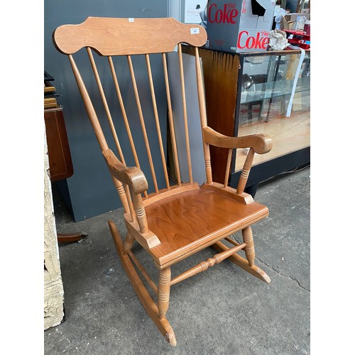 68 - Light wood rocking chair with arm rests.