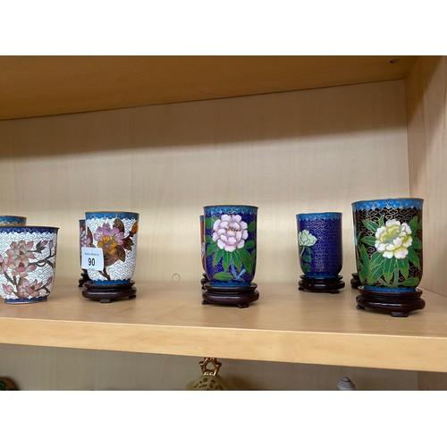 90 - A Shelf of Chinese Cloisonné drinking cups with wooden stands,