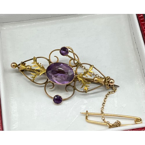 5 - 9ct gold suffragette style brooch set with one large amethyst stones off set by two smaller amethyst... 